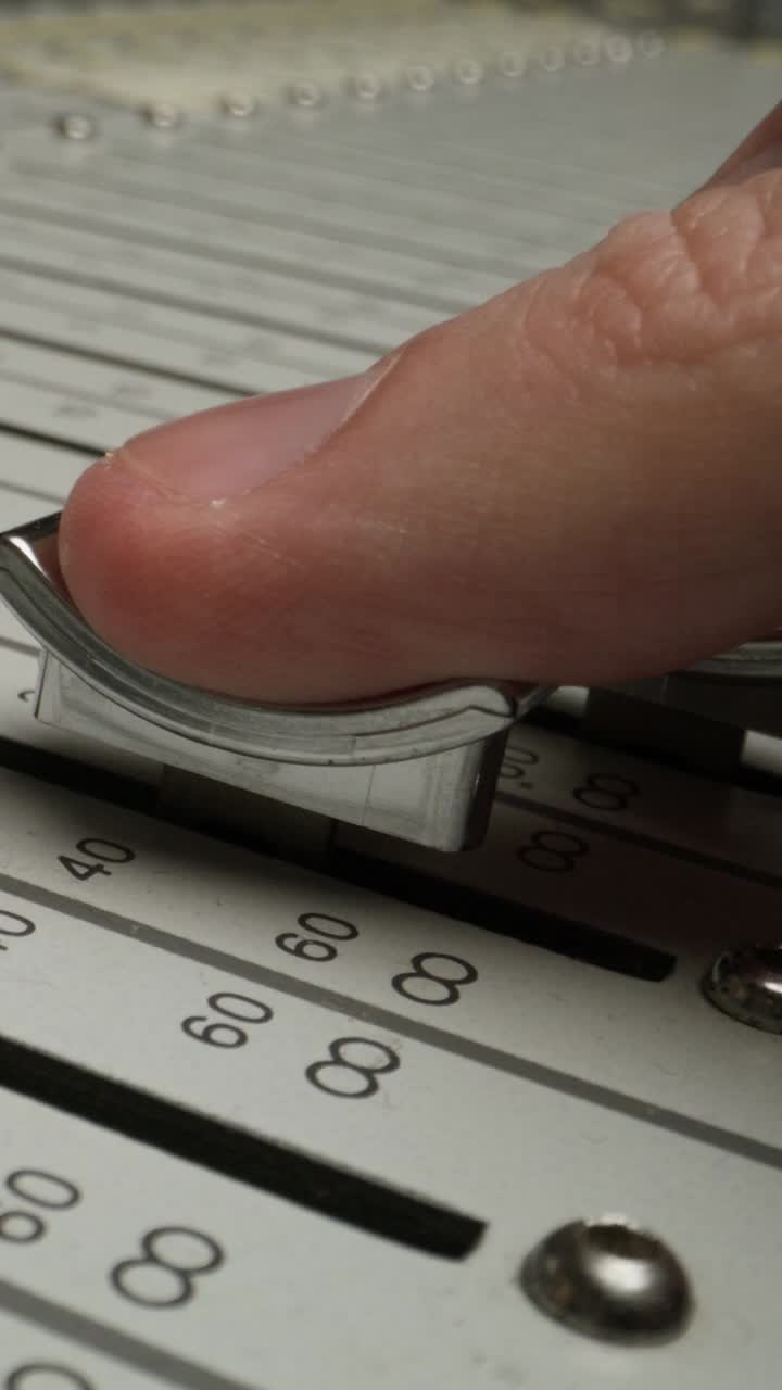 ajustando con el dedo un desvanecedor en un mezclador de audio vintage