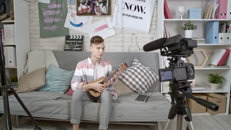 un niño adolescente filmando un tutorial de ukulele