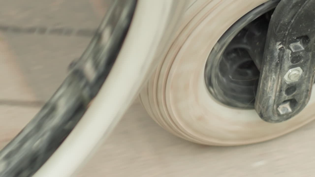 CloseUp Wheelchair Caster Wheel Rolling On Dusty Pavement, Worn Rubber And Plastic Fork, Slow Rotation, Gritty Urban Texture, Focus On Rim And Axle, Subtle Movement Conveying Resilience
