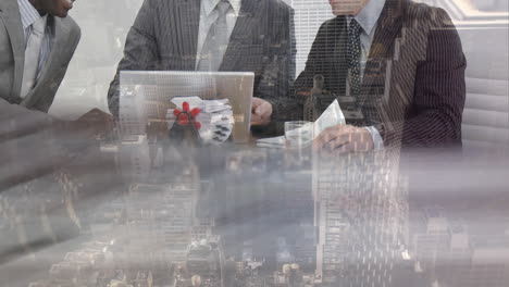 mid section of business people discussing over laptop at office against cityscape in background