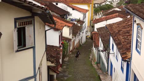 el viajero camina por una estrecha pendiente empedrada entre edificios históricos en ouro preto, mg, brasil