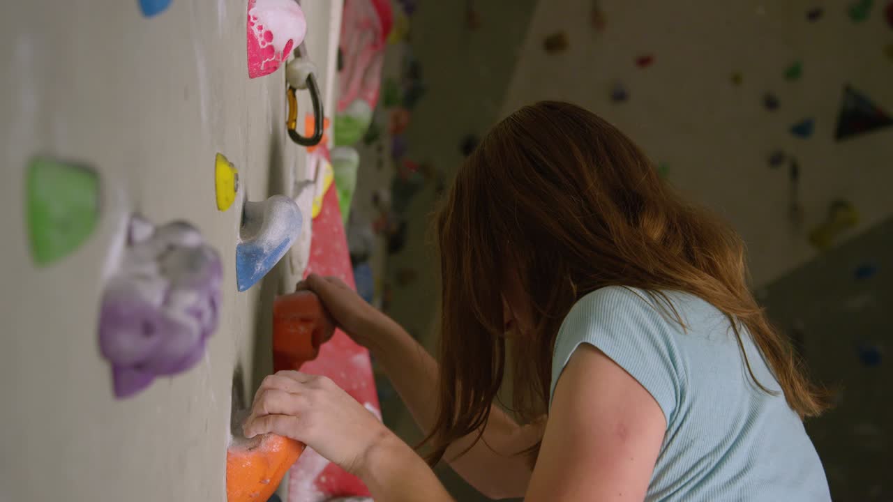 cerca, dof: adolescente enlaza la cuerda en un carabiner mientras sube a la pared interior