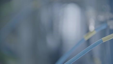 close-up caucasian hand tightens blue network cable in a server room, slider