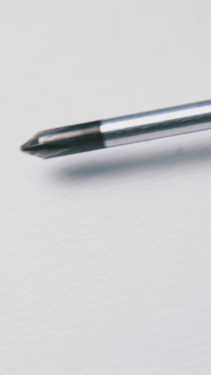 new crosshead screwdriver with red and black plastic handle lies on white background extreme close view