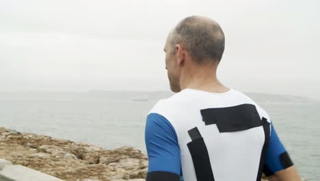 triatleta masculino trotando a lo largo del paseo marítimo