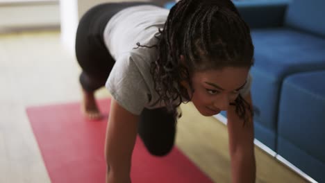 joven atleta afroamericana trabajando en la sala de estar