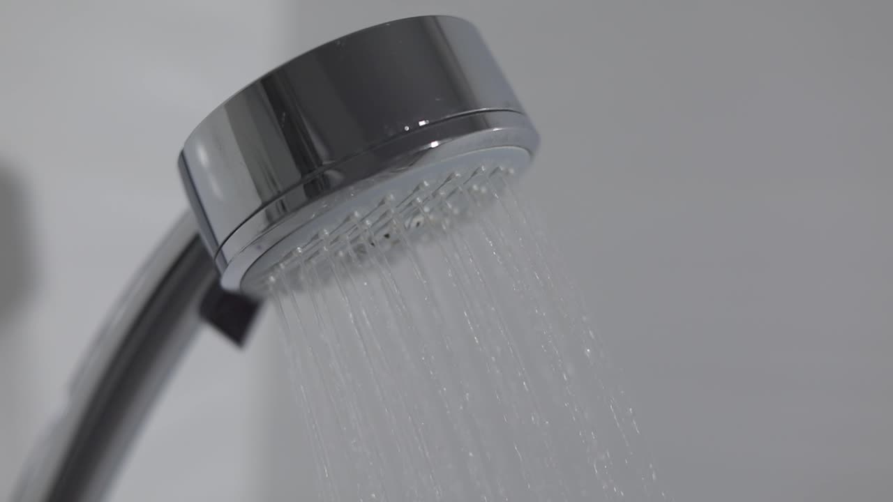 cabeza de ducha en el baño con gotas de agua que fluyen. gotas de water en la cabeza de ducha