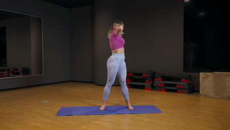 woman stretching on exercise mat - wide shot