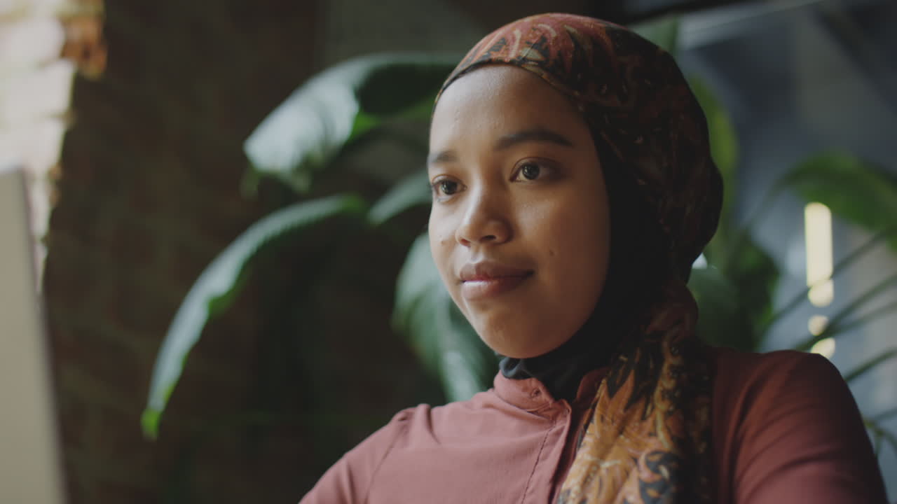 Vrouw in hijab gebruikt laptop in café