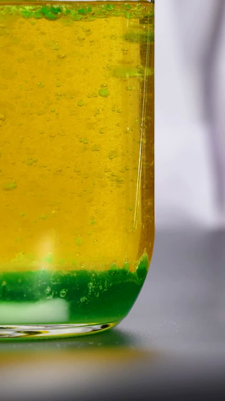 una vibrante reacción química se desarrolla en un vaso de laboratorio, mostrando cambios dinámicos de color y separación de líquidos