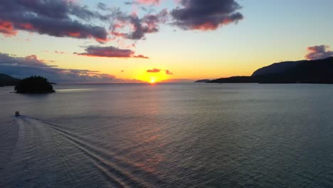 drone aéreo disparado hacia la puesta de sol sobre el lago