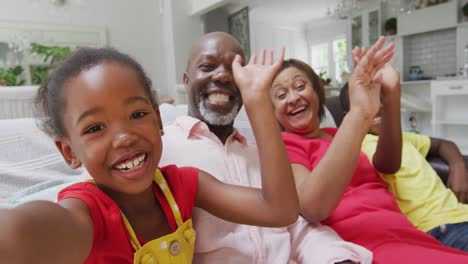 happy african american grandparents and grandchildren sitting on sofa, having video call