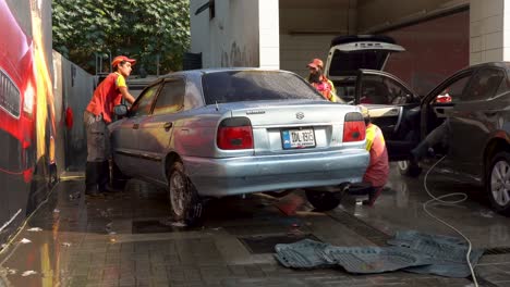 car wash workers cleaning a car