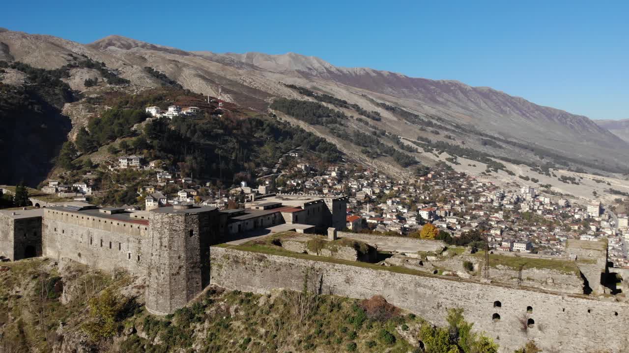 paredes de piedra de la fortaleza histórica sobre la ciudad de gjirokastra en la ladera de la montaña