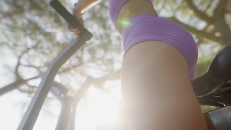 woman exercising outdoors on fitness equipment