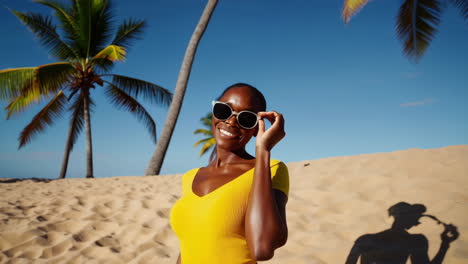 woman smiling in sunglasses on a tropical beach