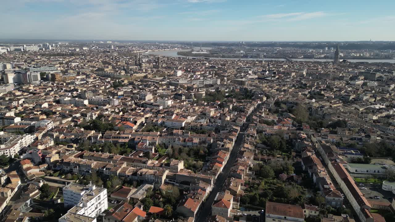 Rue de Pessac e centro città con basilica e fiume Garonna in lontananza, Bordeaux, Francia. Panoramica aerea verso sinistra.