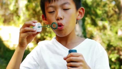 boy blowing bubble with wand