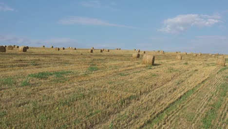 blue sky above rolled straw bales 4k aerial video