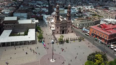 flight over plaza de la patria approaching the cathedral of aguascalientes, mexico, during the morning activities of a sunny sunday
