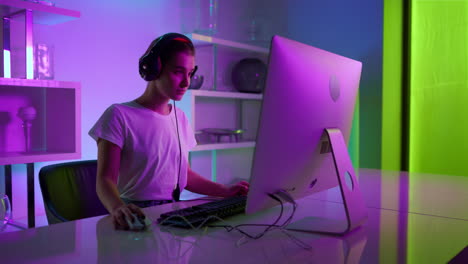 Esport-Gamer-Posiert-Mit-Headset-Im-Neon-Haus.-Ernsthaftes-Mädchen,-Das-Sich-Ausruht-Und-Ein-Videospiel-Spielt