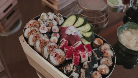 variety of colorful sushi rolls artfully arranged with cucumber slices and tuna sashimi