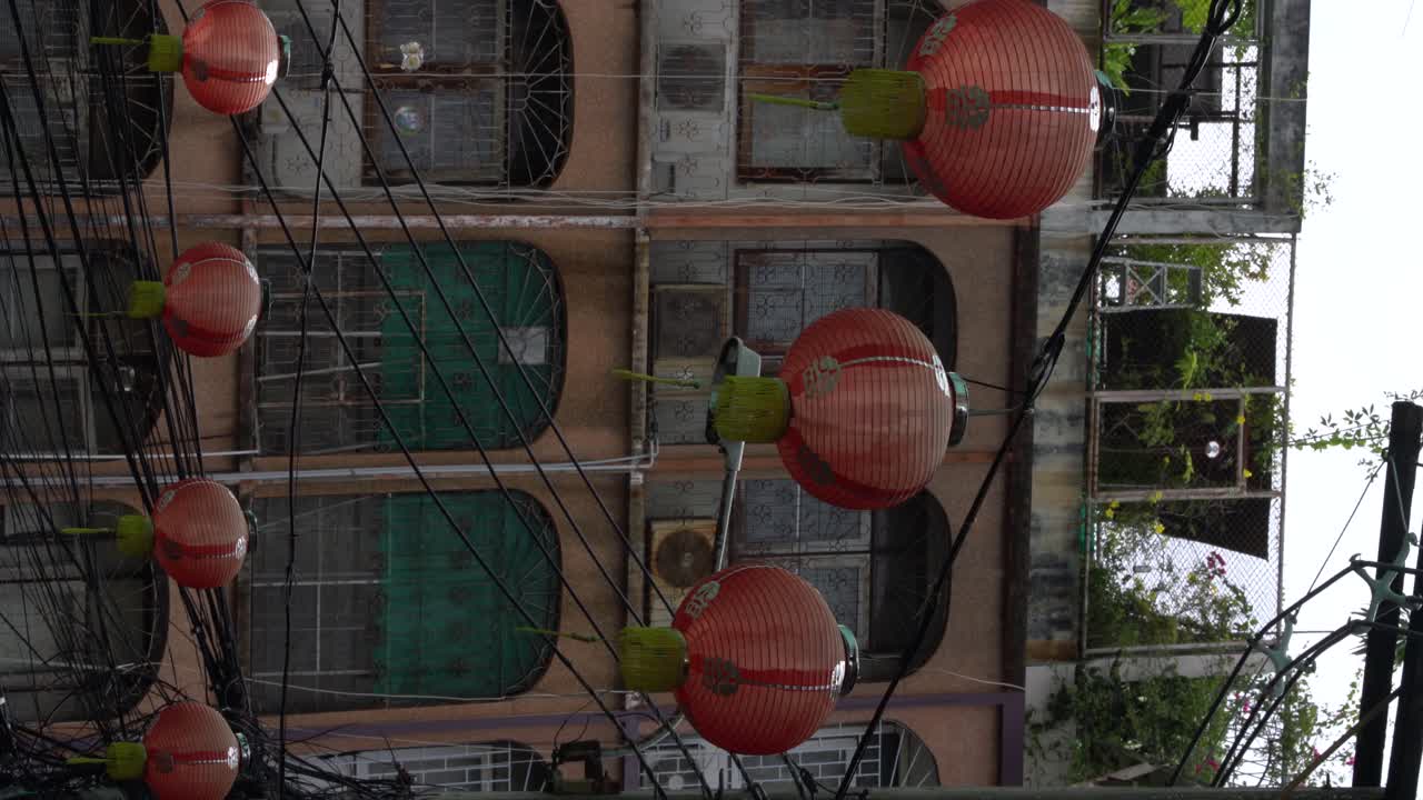 video vertical: las linternas rojas soplan con el viento y adornan un pequeño callejón en el barrio chino de bangkok, tailandia