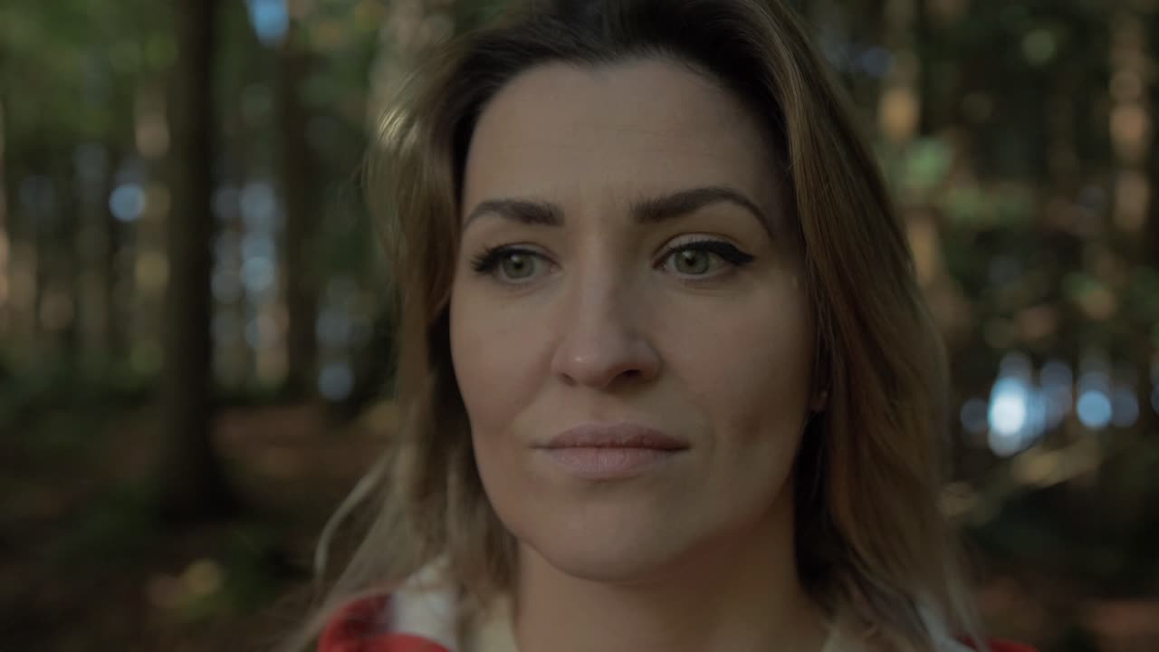 hermoso retrato femenino caminando a través del bosque de luz solar