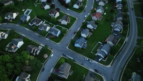 classic american suburban neighborhood during spring season dusk, with neatly lined houses, tree-filled yards and winding streets. pennsylvania, united states. aerial top down shot.