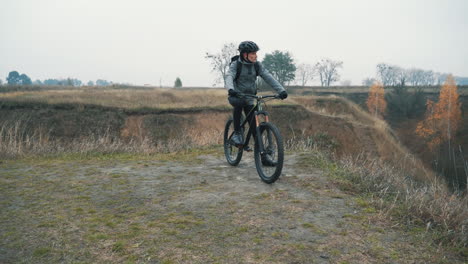 丘の下でマウンテン バイクに乗る準備ができている男性サイクリスト