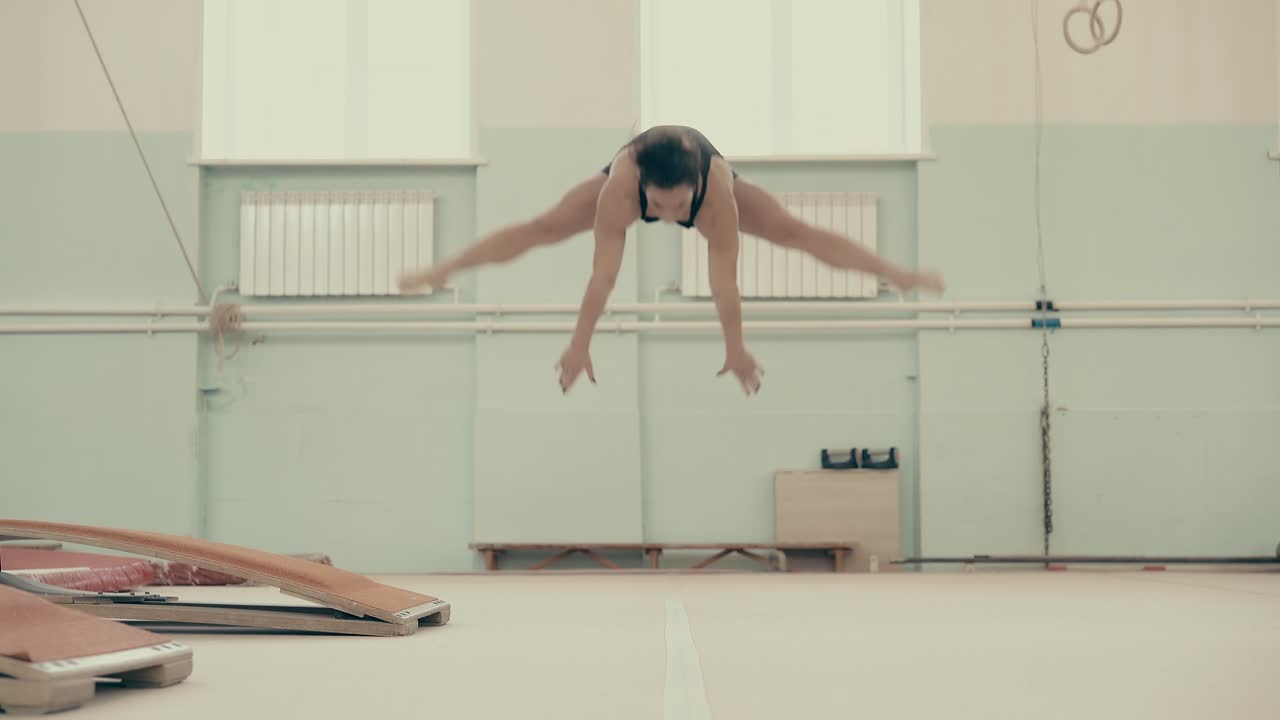 chica atlética en el gimnasio realiza un conjunto acrobático
