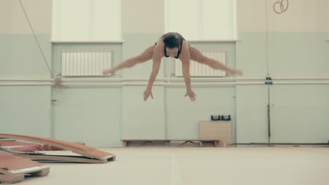 girl athletic build in the gym performs an acrobatic set