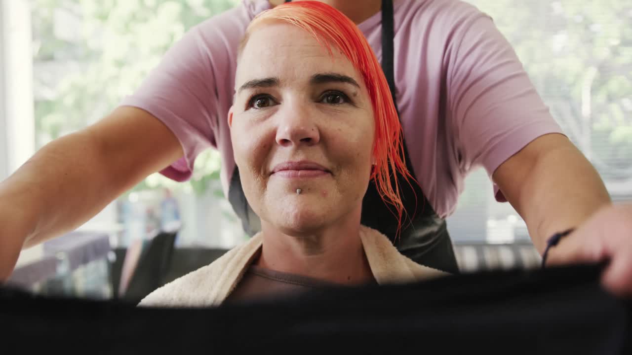 Front view hairdresser putting protection around woman neck