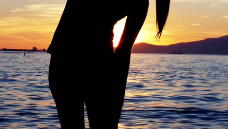 mujer realizando yoga en la playa