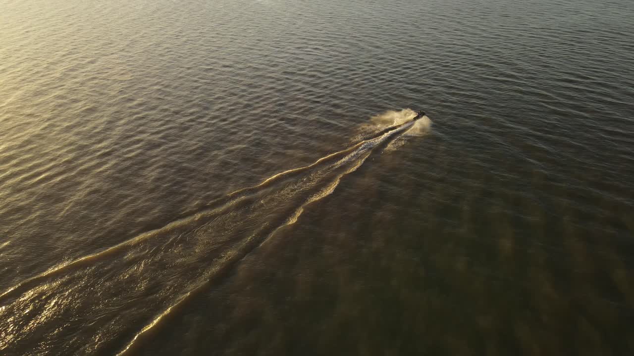 toma cinematográfica de aviones no tripulados de un crucero en moto de agua en el río durante la luz del atardecer en cámara lenta