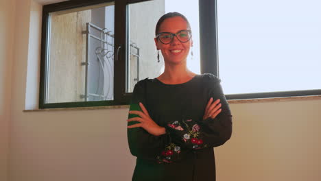 Woman-with-glasses-in-modern-office-workspace-looking-on-camera