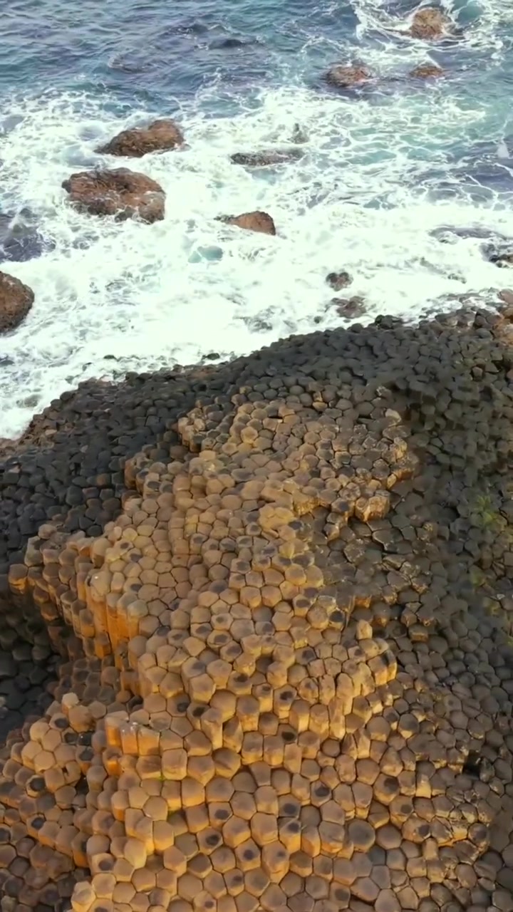 Tight rotating social ratio aerial video of The Giant's Causeway in Bushmills, County Antrim in Northern Ireland, United Kingdom. Produced in 1080x1920 vertical ratio with Rec709 color.