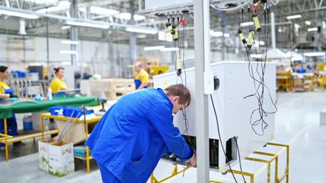 interior of industrial working place at factory. worker at plant in blue uniform checks the production process. technic concept.