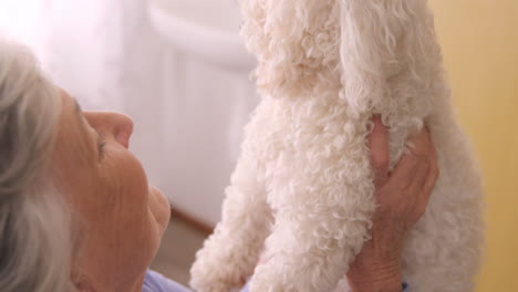 una mujer mayor sonriente sosteniendo un perro