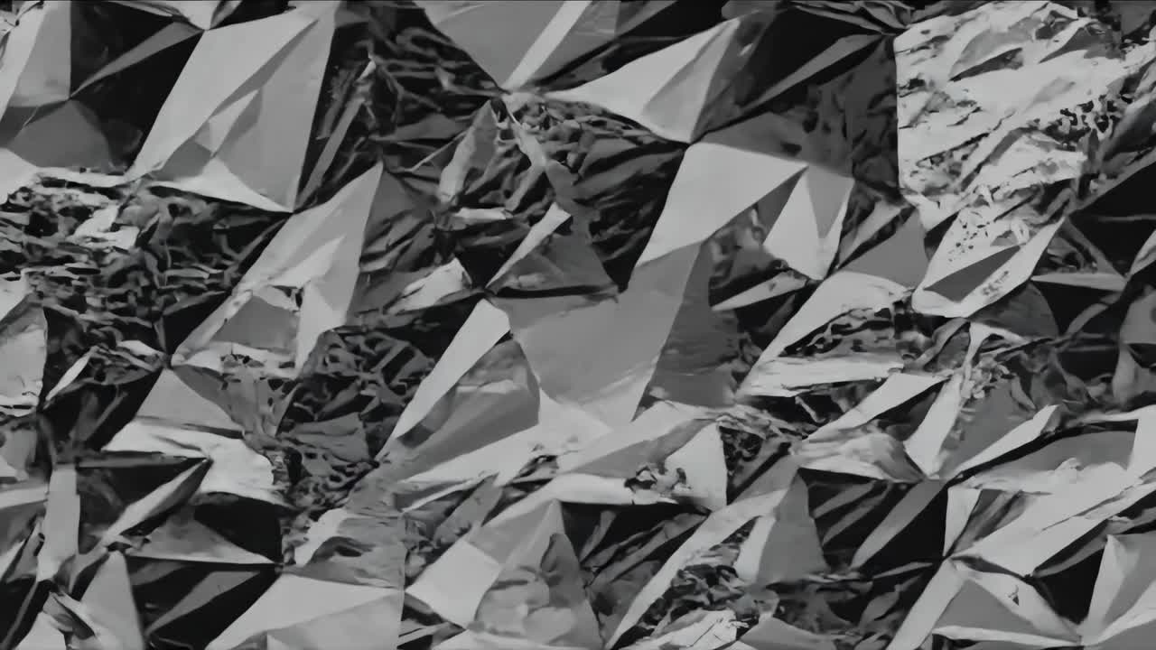 Dynamic sequence of reflective crumpled foil showcasing intricate textures and light interplay, creating a captivating visual flow in monochrome tones
