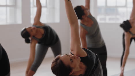 Hermosa-Mujer-Hispana-De-Yoga-Practicando-Meditación-En-Pose-Traingle-Con-Un-Grupo-De-Mujeres-Multirraciales-Disfrutando-De-Un-Estilo-De-Vida-Saludable-Haciendo-Ejercicio-En-Un-Gimnasio