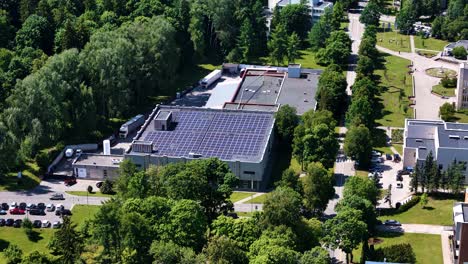 Commercial building with solar panels on top in Birstonas town, aerial orbit view