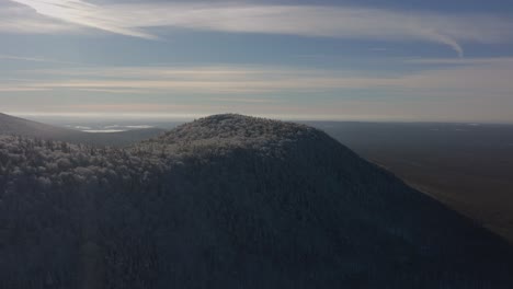 snowy tree covered mountain at wintertime sunrise in southern quebec, canada