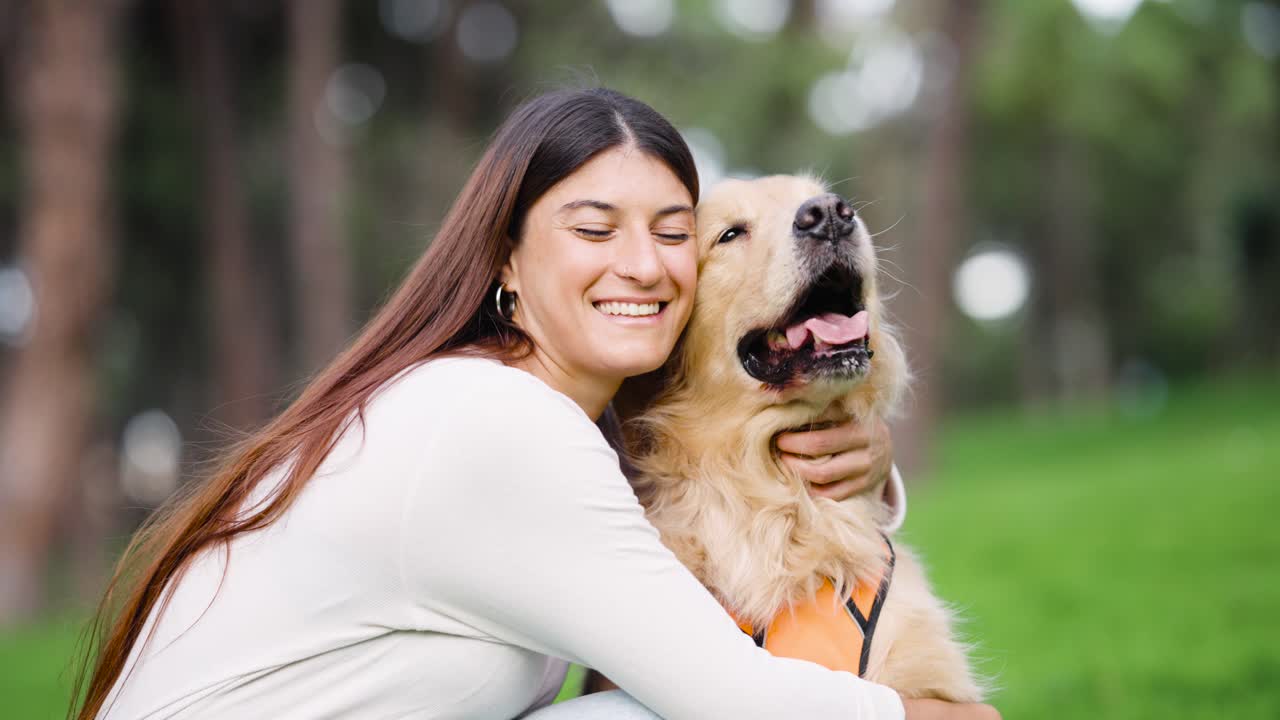 Joven abrazando cariñosamente a su golden retriever en un parque