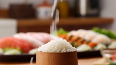 rice being poured into a wooden cup with sushi ingredients in the background