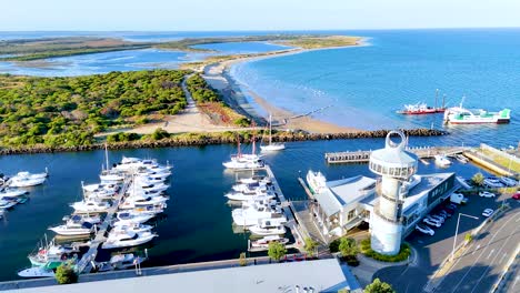 drone footage captures queenscliff marina's boats and iconic lighthouse under clear skies, showcasing the coastal beauty of bellarine peninsula