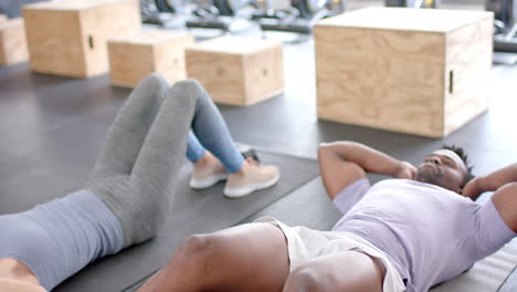 Colocar-Pareja-Diversa-Descansa-Después-De-Hacer-Ejercicio-En-El-Gimnasio.