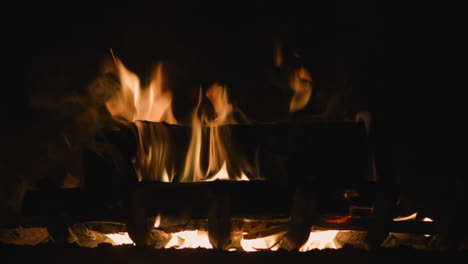 fireplace closeup with medium size flames burning in dark room