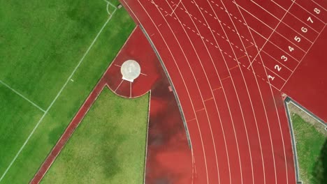 running track at the stadium, color is orange brick, high angle view by drone.