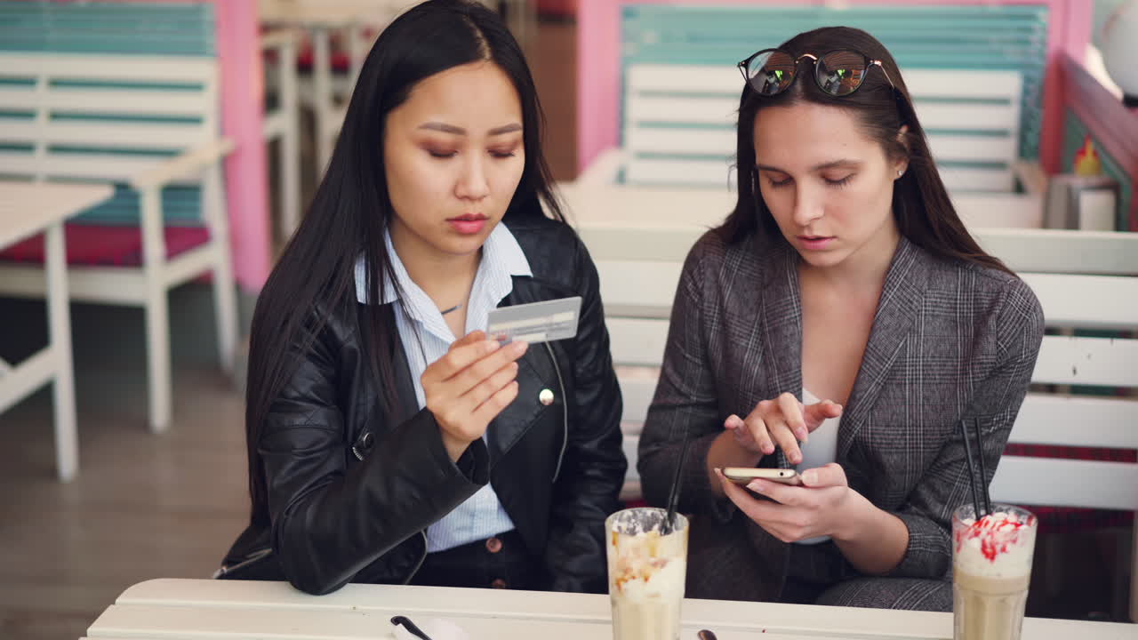 Two women discussing a payment at a cafe